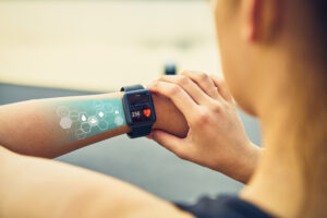 young woman checking sports watch with screen healthcare icon