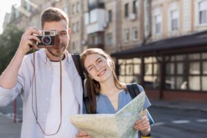 tourist couple posing outdoors with camera map