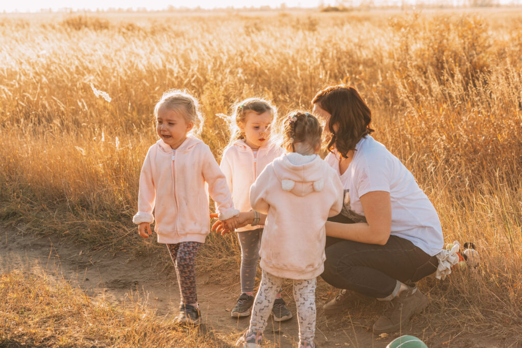 mom walk with daughters triplets one girl is crying kids tantrums street upset baby park